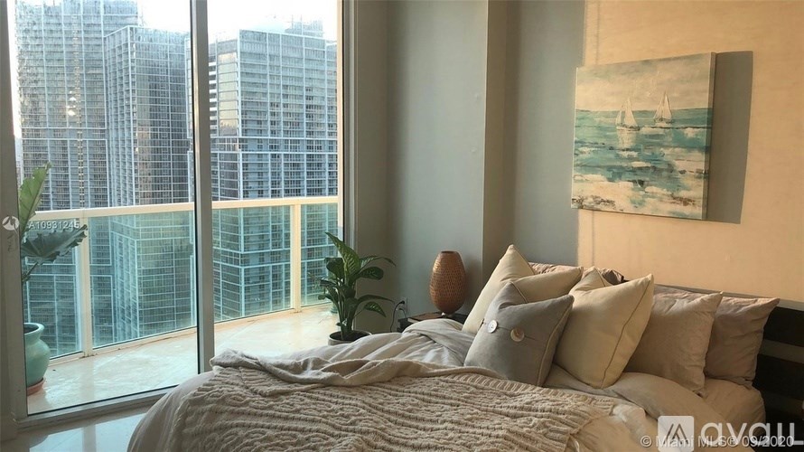 A bedroom with a large bed and a painting on the wall.