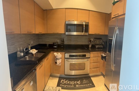 A kitchen with wooden cabinets and a black countertop.