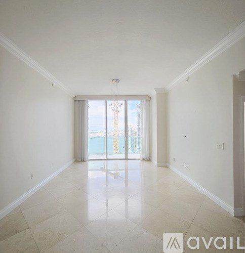 A cityscape with tall buildings and a body of water in the foreground.