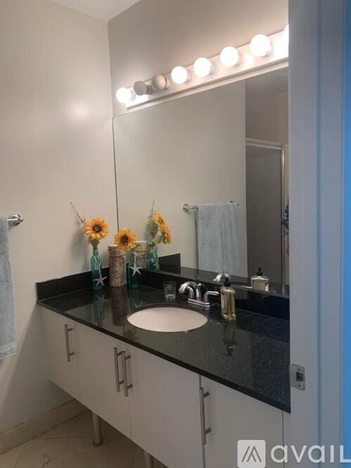 A bathroom with a sink, mirror, and lights.