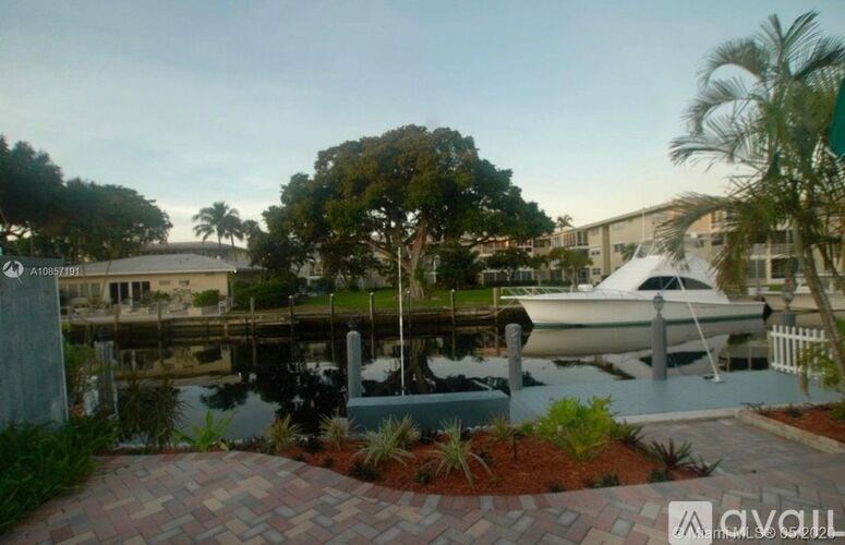 A boat is docked at a marina with a building in the background.