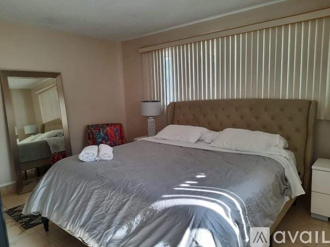 A bedroom with a large bed and a mirror on the wall.