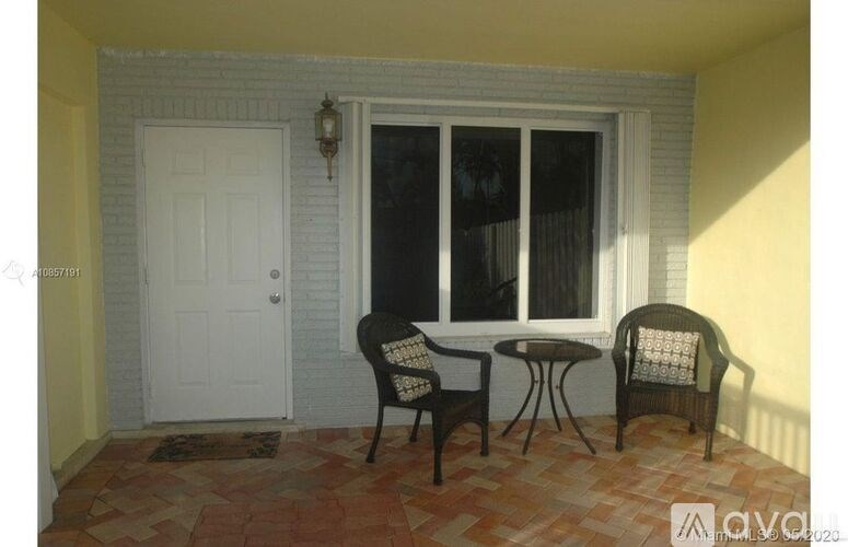 A patio with a table and chairs and a door.