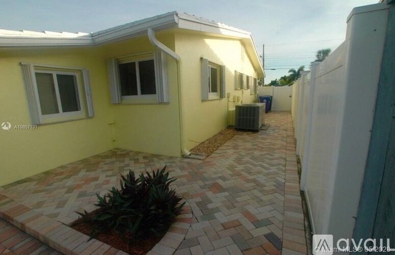 A yellow house with a brick walkway in front.