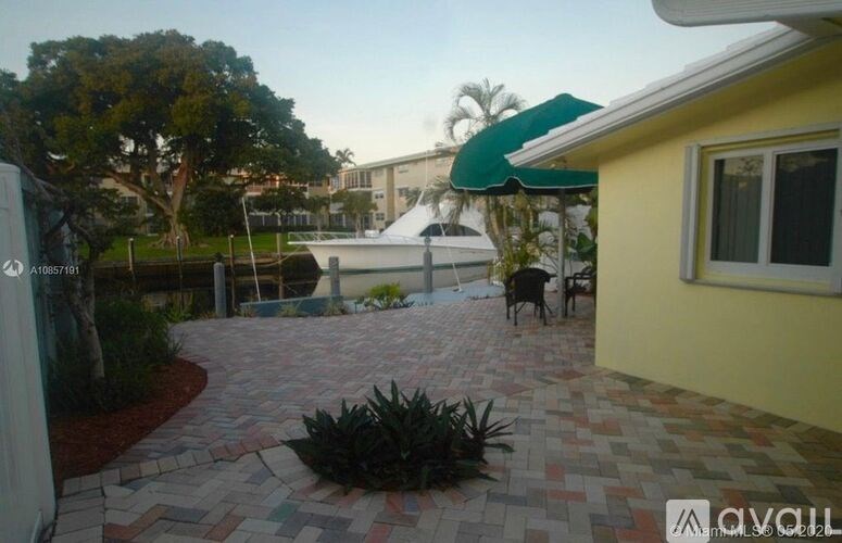 A patio with a table and chairs is surrounded by a brick wall.