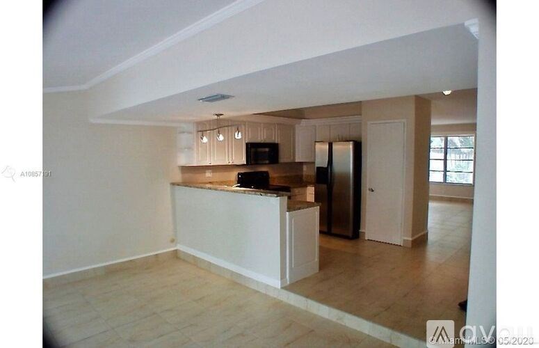 A kitchen with a refrigerator, microwave, and oven.