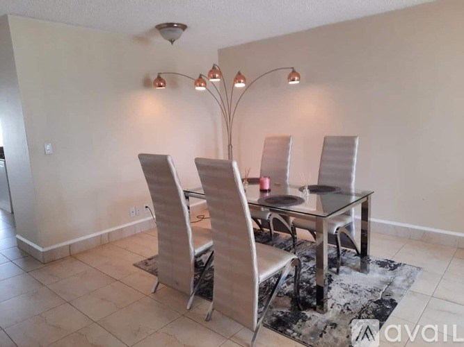A dining room with a glass table and chairs.