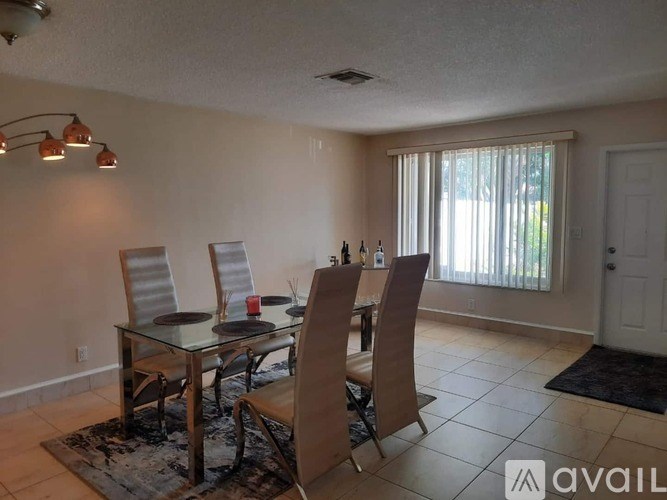 A dining room with a glass table and chairs.