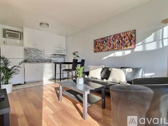 A living room with a grey couch and a wooden floor.
