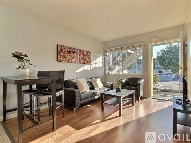 A living room with a couch, chairs, and a television.