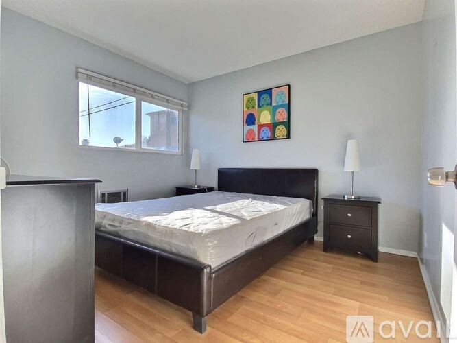 A bedroom with a bed, nightstand, and lamp.