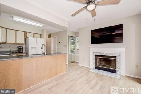 A modern kitchen with wooden cabinets and a white fireplace.
