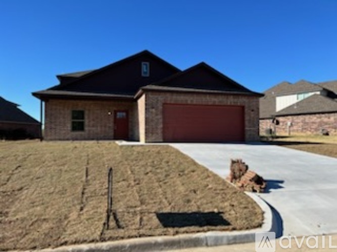 A house with a red garage door is surrounded by a grassy area.