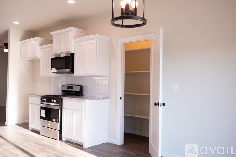 A kitchen with white cabinets and a black stove top oven.