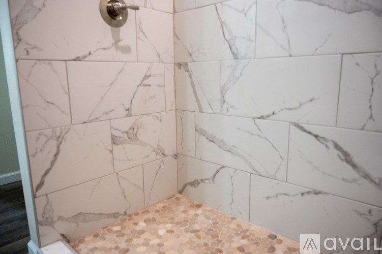 A bathroom with marble tiles on the wall.