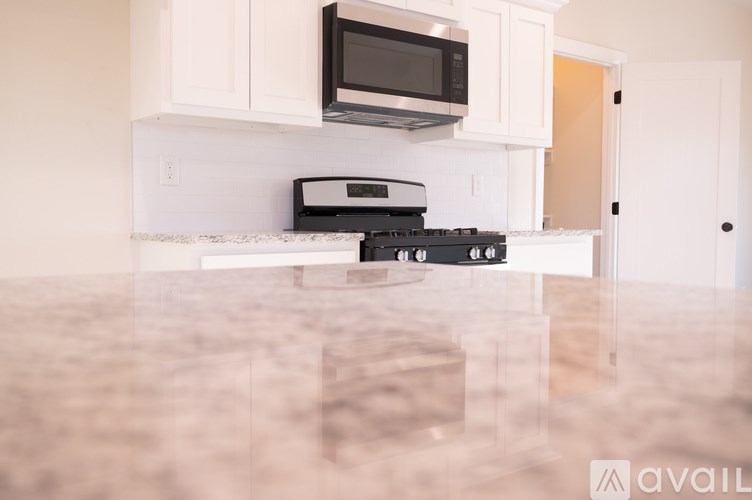 A kitchen with a black stove top oven and a black microwave above it.