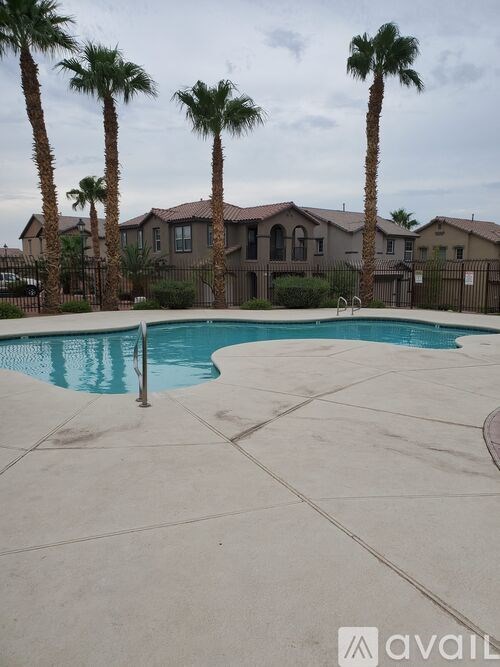 A pool surrounded by palm trees and apartment buildings.