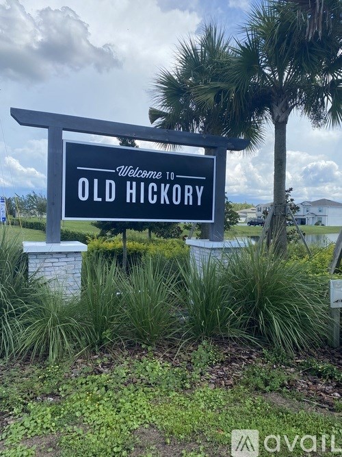 A sign that says "Welcome to OLD HICKORY" is in front of a palm tree.
