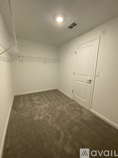 A room with a carpeted floor and a white door.
