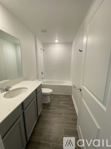 A bathroom with a toilet, sink, and bathtub.