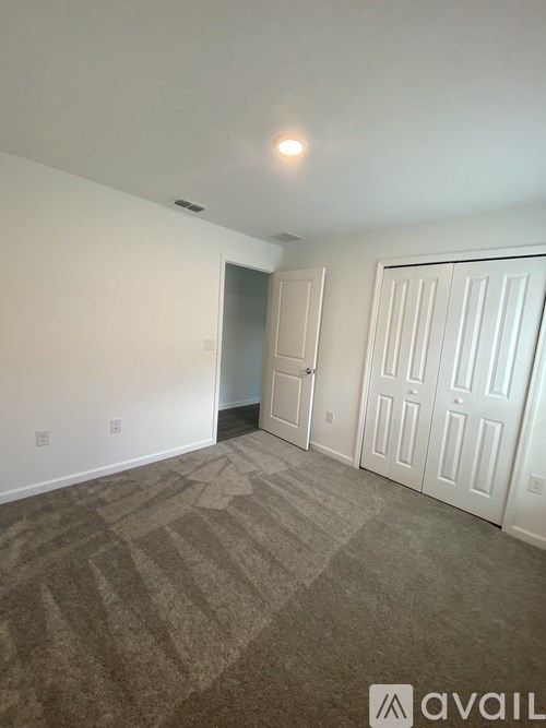 A room with a carpeted floor and a white door.