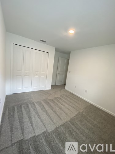 A room with a carpeted floor and a white door.