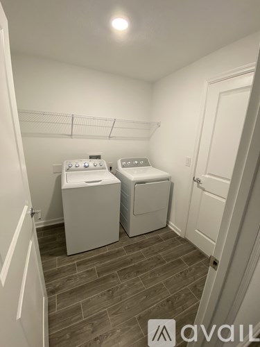 A laundry room with two washing machines and a dryer.
