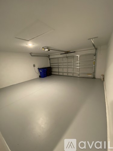 A long, narrow room with a blue bin and a metal shelving unit.