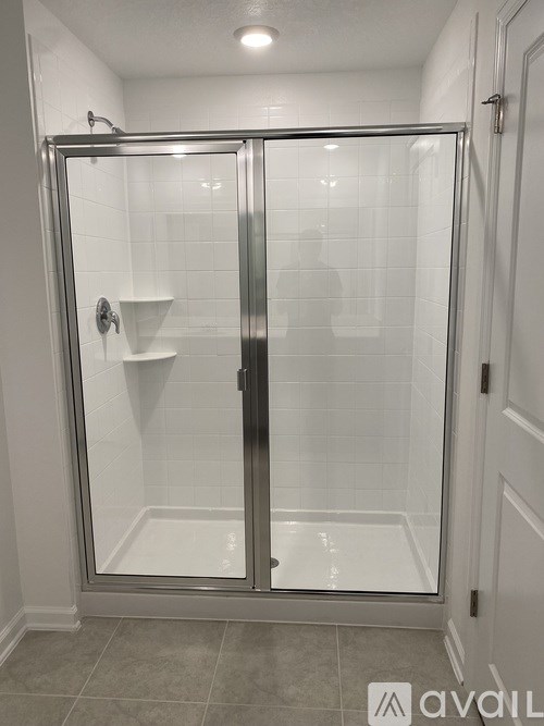 A bathroom with a glass shower door and a white sink.