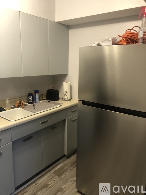 A kitchen with a stainless steel refrigerator and white cabinets.