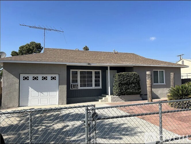 A house with a grey roof and a white garage door.