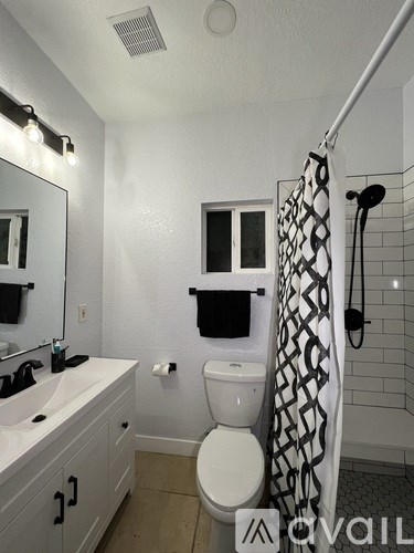 A bathroom with a toilet, sink, and shower.