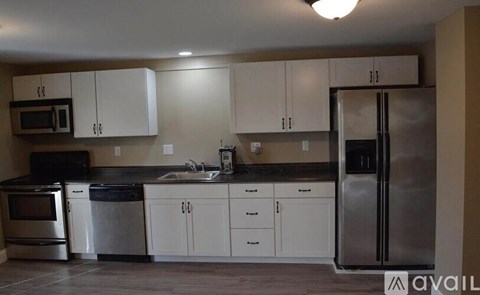 A kitchen with white cabinets and stainless steel appliances.