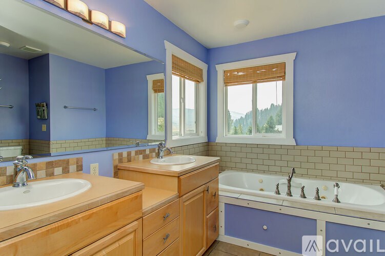 A bathroom with blue walls and wooden furniture.