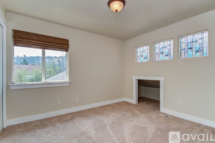 A room with a fireplace and a window with blinds.