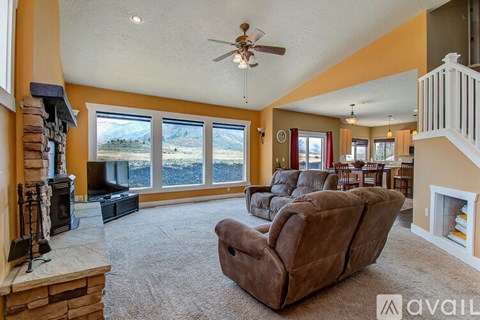A living room with a brown leather chair and a fireplace.