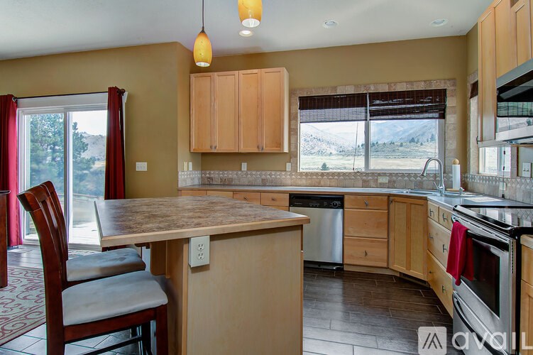 A kitchen with a table and chairs in front of a window.