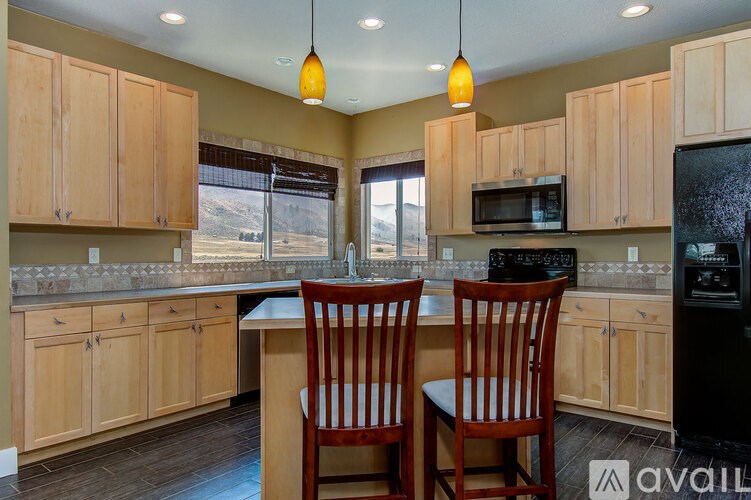 A kitchen with wooden cabinets and a black refrigerator.
