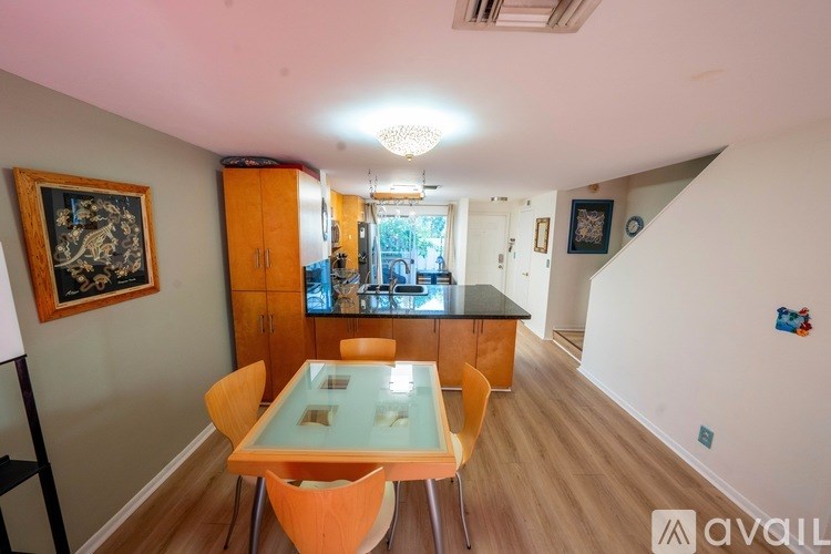 A room with a desk, a computer, a television, and a painting on the wall.