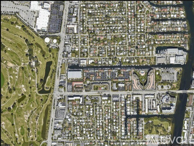 A bird's eye view of a residential area with houses and a river running through it.