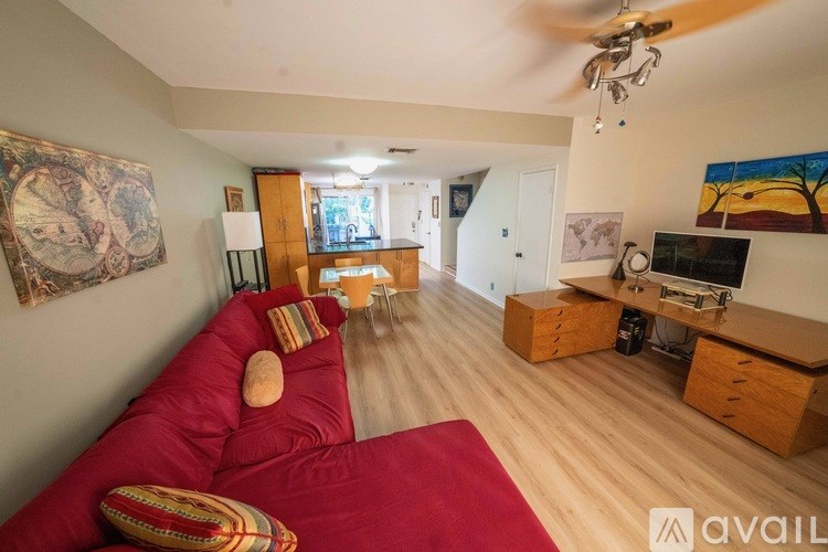 A living room with a red couch and a television.