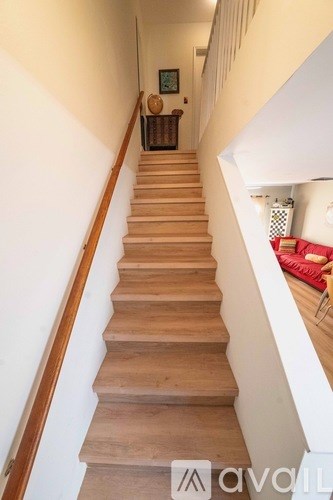 A wooden staircase with a white wall on the side.