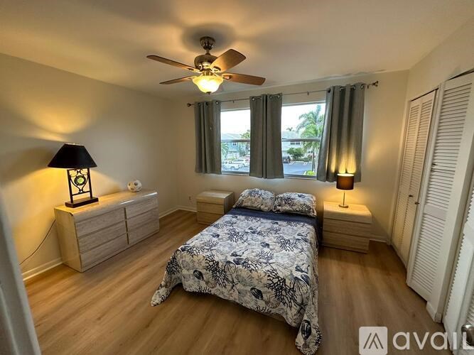A bedroom with a bed, nightstand, and a ceiling fan.