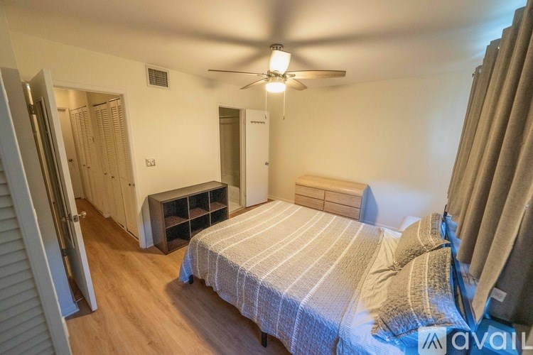 A bathroom with a white toilet and a white towel hanging on the shower curtain.