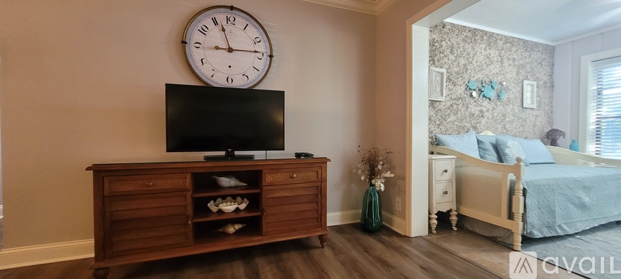 A bedroom with a bed, a dresser, and a television.