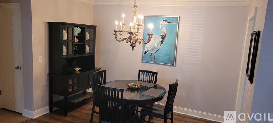 A dining room with a black table and chairs.