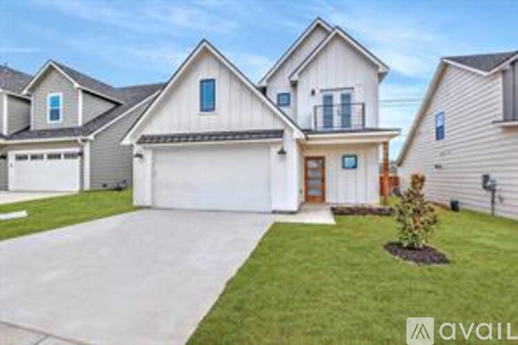 A house with a garage and a driveway in front.