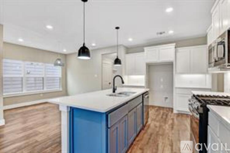 A kitchen with a blue cabinet and wooden floors.