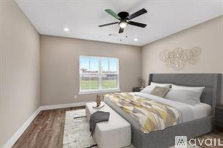 A bedroom with a large bed and a ceiling fan.