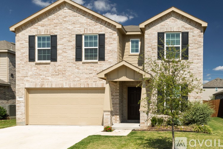 A two-story house with a garage and a tree in front.